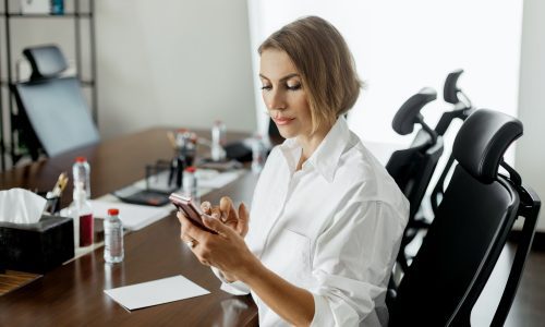 A young woman uses the phone while working in the office